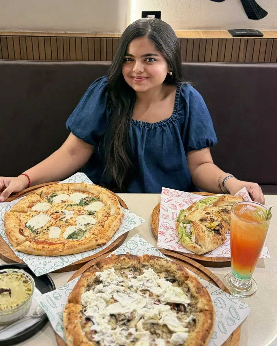 Guest with wood-fired pizzas and a mocktail at Pizzaiiolo