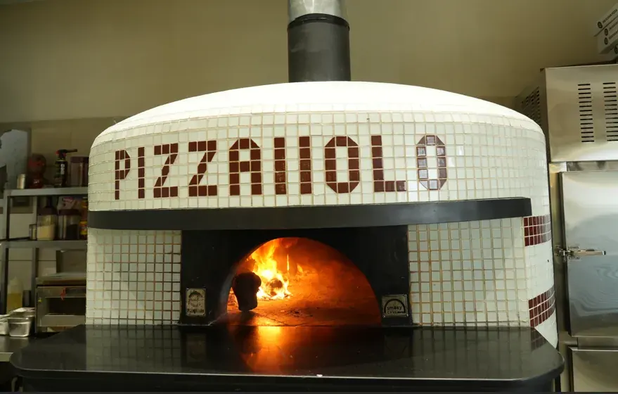 The tiled Pizzaiiolo wood-fired oven with flames inside